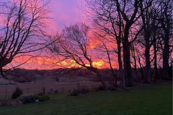 Red night skies over the rolling landscape
